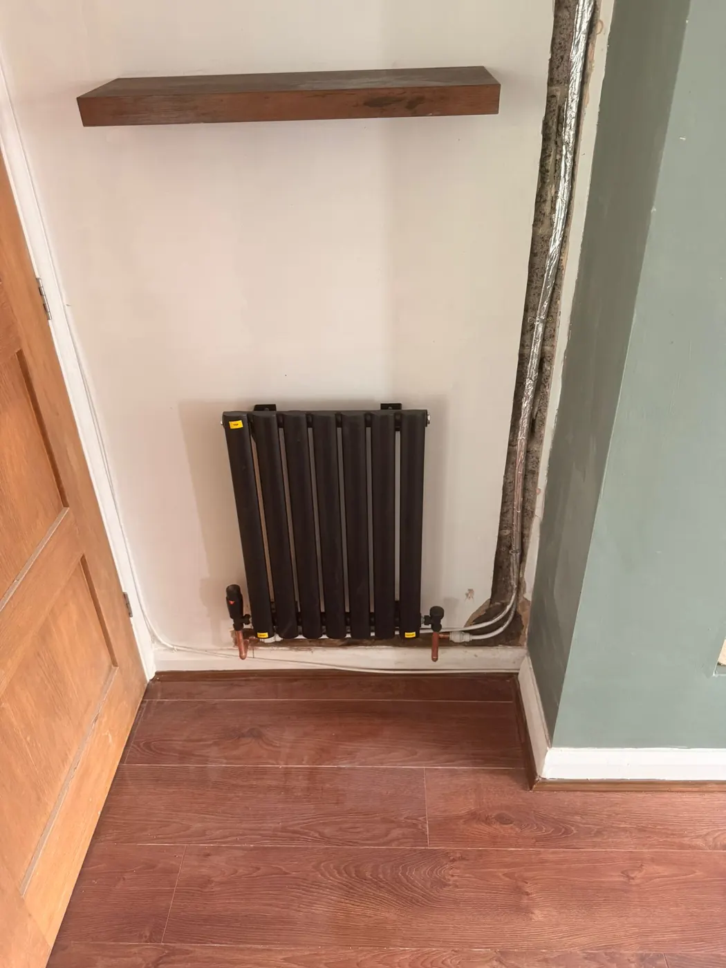 Black column radiator installed by FluidFlo Heating Services